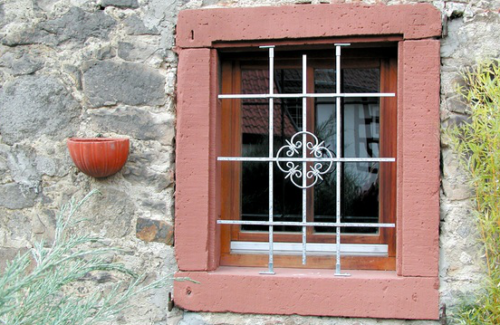 In roten Sandstein gerahmtes Fenster mit Fenstergitter