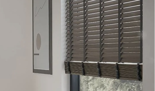 Dunkle Holzjalousien halb aufgerollt