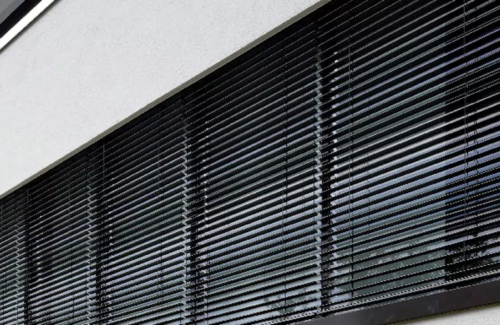 Verdunkelungsanlage hinter Fenster mit Jalousie.