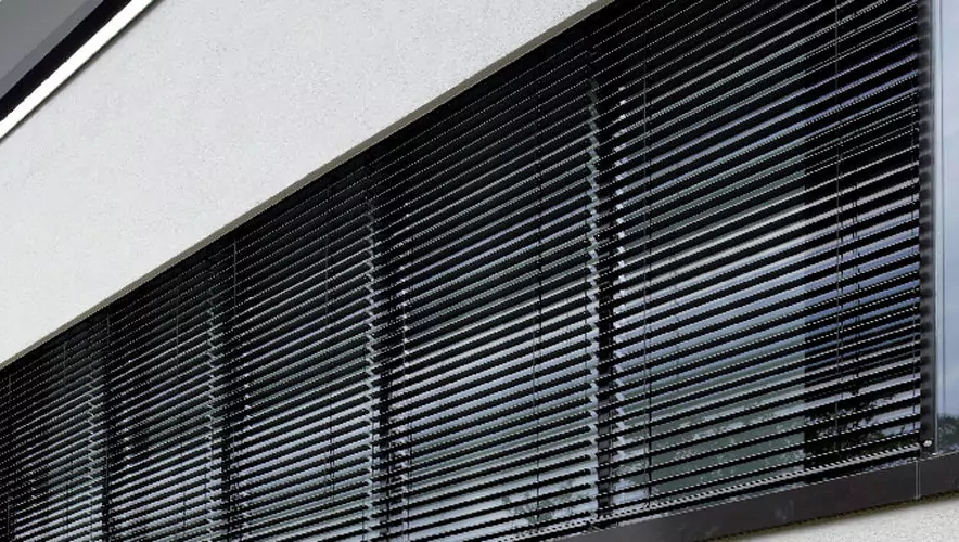 Verdunkelungsanlage hinter Fenster mit Jalousie.