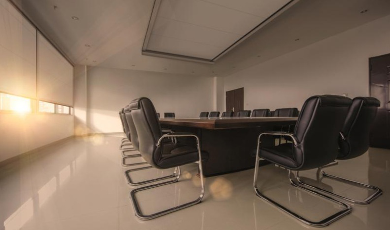 Ein Seminarraum wird von weißen Verdunkelungsanlagen beschattet.